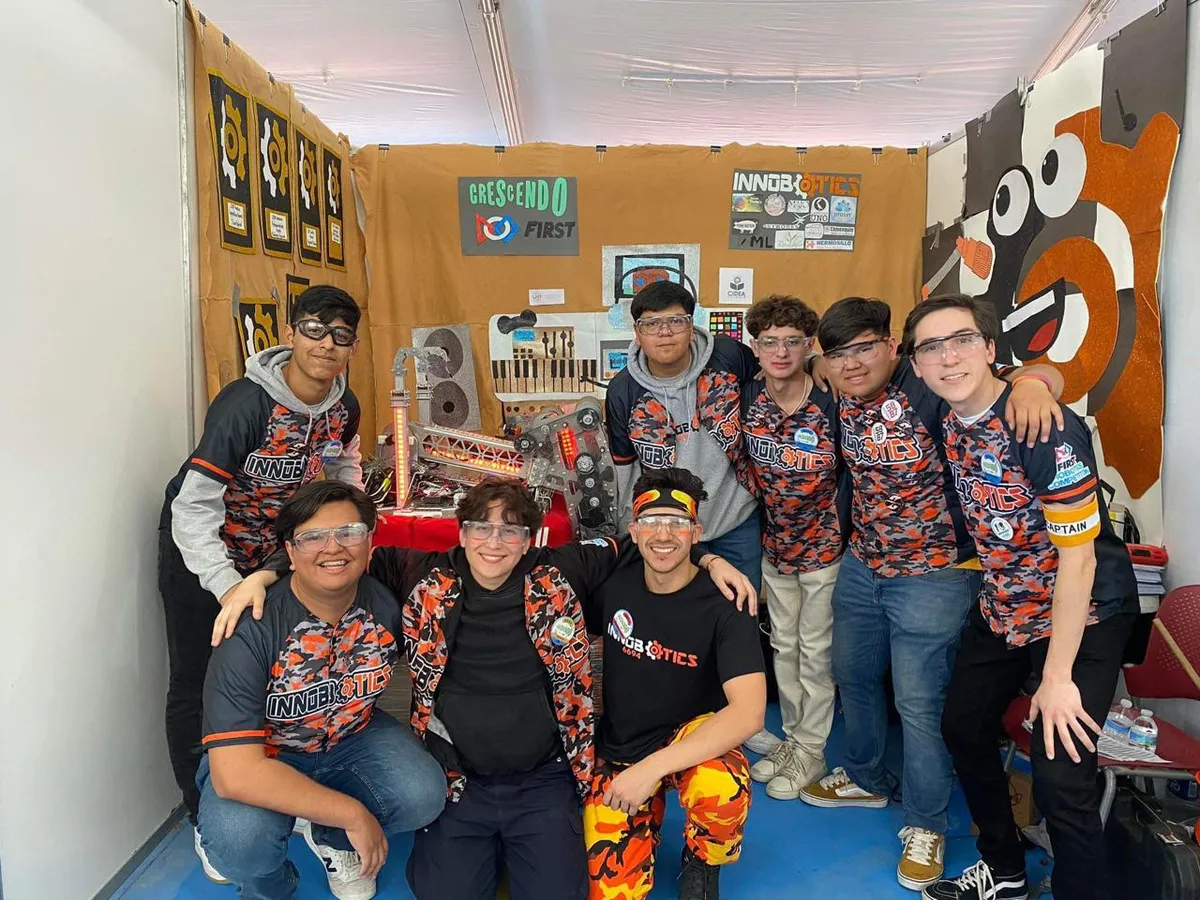 Innobotics pit crew posing with the 6694 robot in the team pit