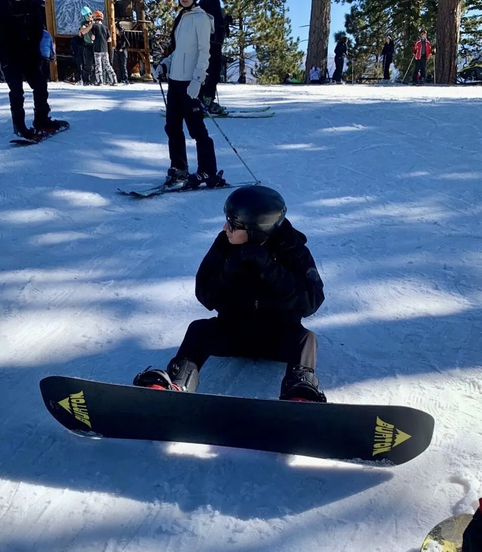 Sitting on the snow with a snowboard