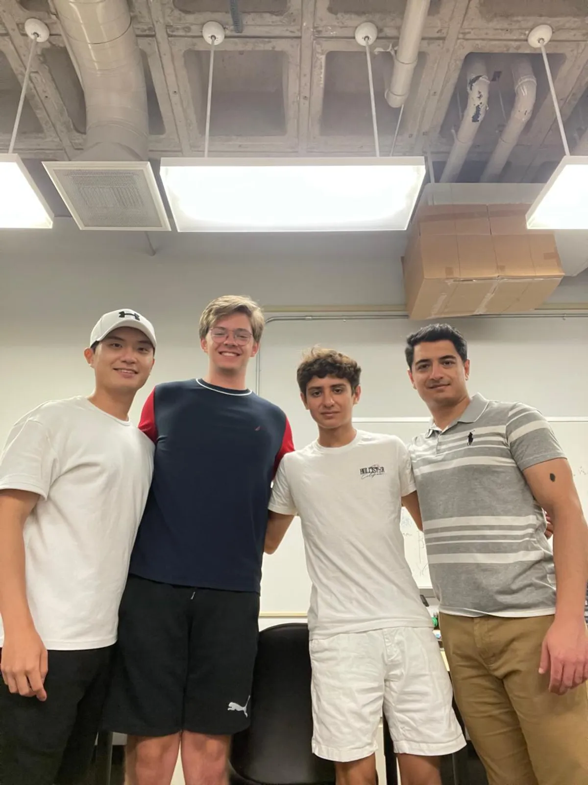 Research team of four posing together in the UCSD lab